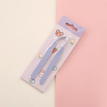 Eyebrow tweezers in a decorative packaging on a pink and beige background