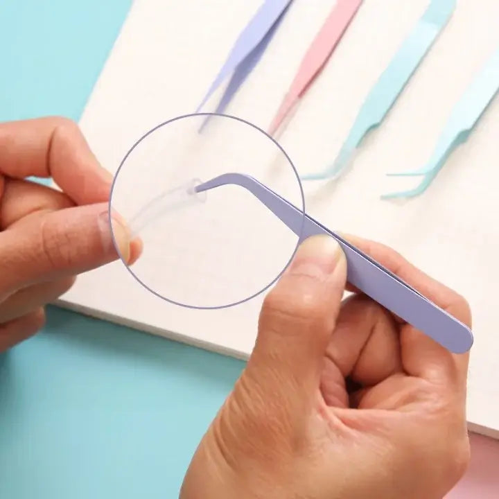 Person using a small tool to cut a piece of paper on a light blue background