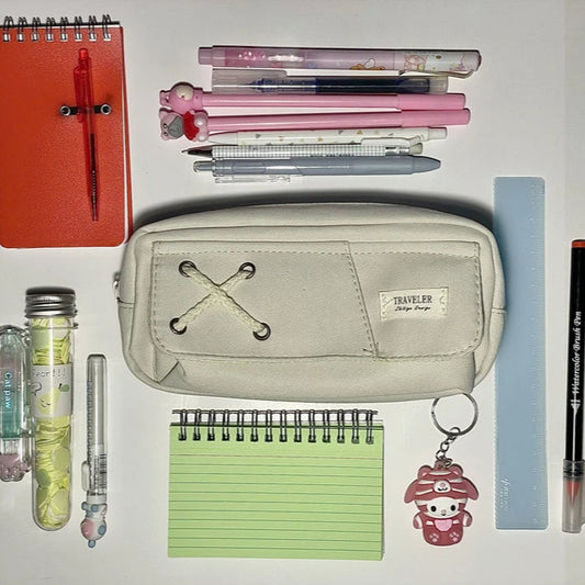 Collection of stationery items including a notebook, pens, and a pencil case on a white background