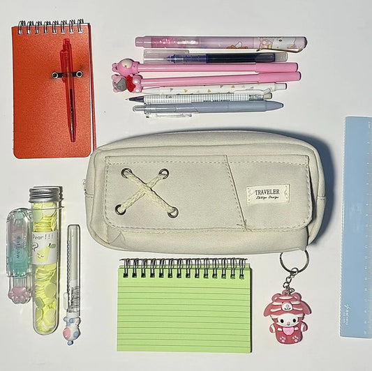 Collection of stationery items including a notebook, pens, and a pouch on a white background