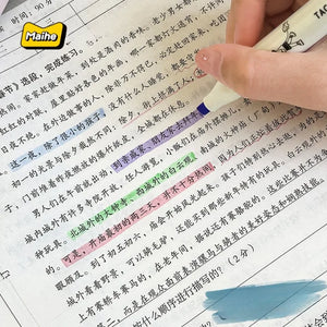 Hand holding a pen over a book with highlighted text, featuring the Maihe brand logo.