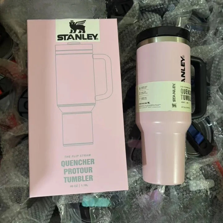 Pink Stanley tumbler with packaging on a textured surface