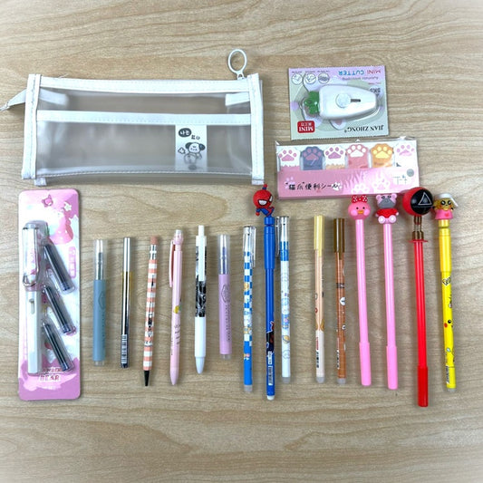 Assorted stationery items including pens and a pencil case on a wooden surface