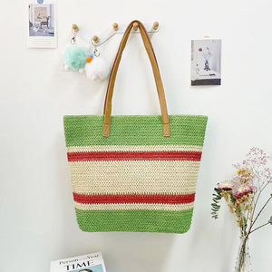 A green and beige striped shoulder bag made of canvas, displayed on a wall hook, with a small inner pocket and zipper closure. It has brown straps and is shown in a home environment.