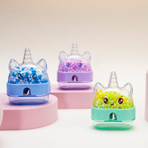 Set of colorful cat-shaped humidifiers on pink stands against a light background