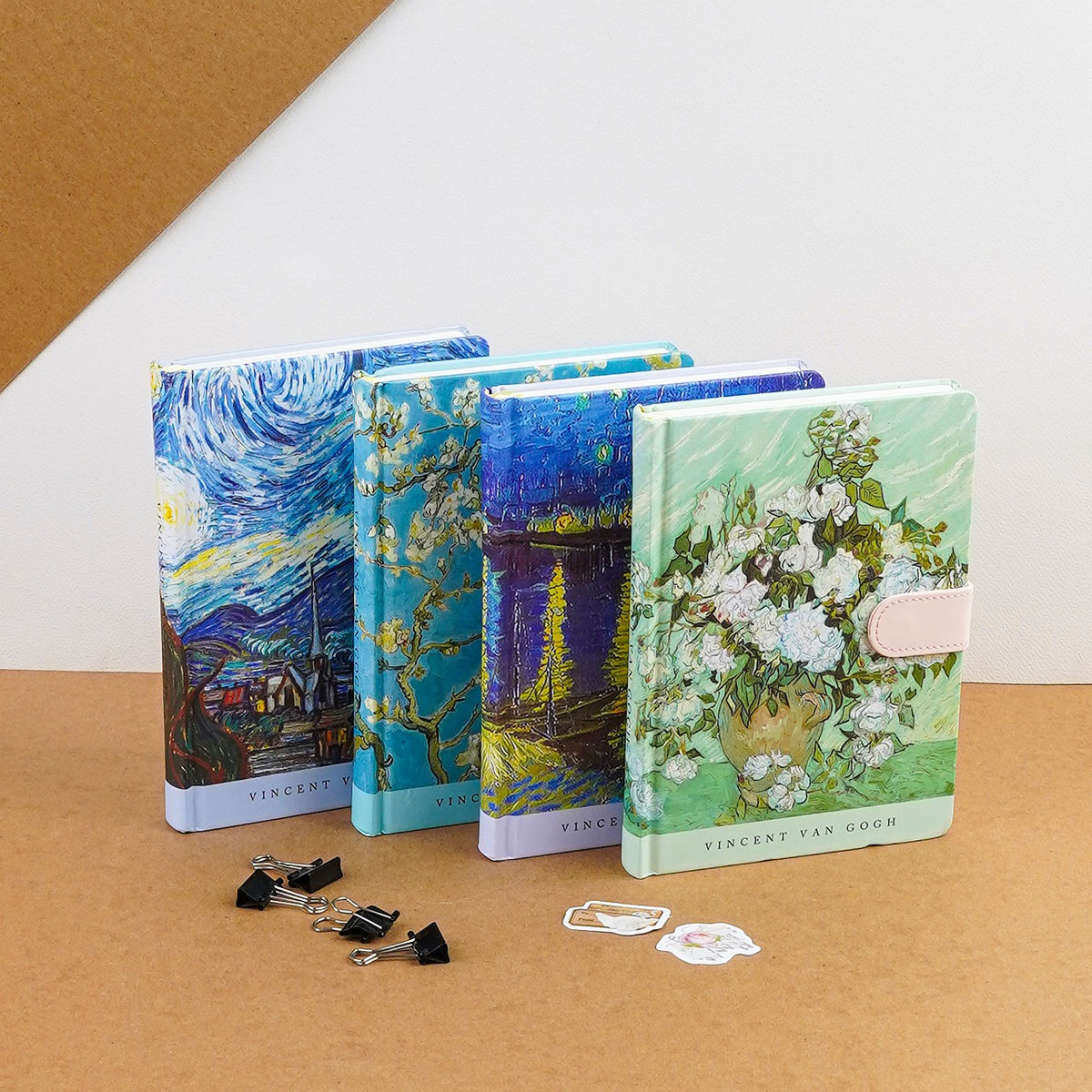 A collection of A5-sized journals with Van Gogh artwork on the covers, displayed alongside paper clips and a small notepad.