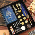 A collection of Harry Potter themed stationery supplies including a journal, pen holder, stamps, bookmarks, wax seal stamp, ink bottle, badge, feather pen, and wax.