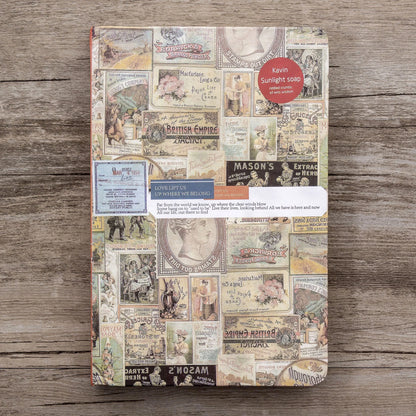 Notebook with vintage-style collage cover on a wooden surface
