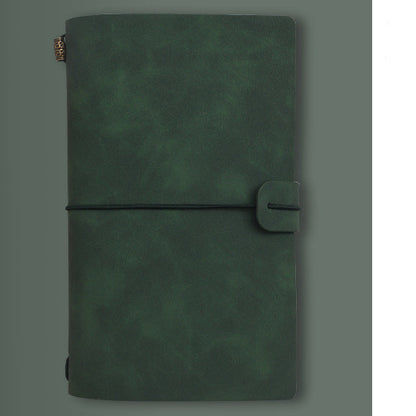 Green notebook with A6 size label on a gray background