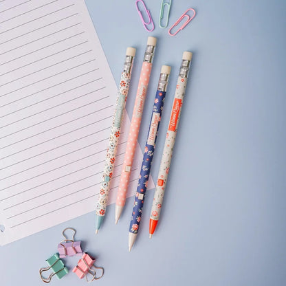 A collection of mechanical pencils with floral and animal print designs, alongside paper clips and a notepad on a blue background.