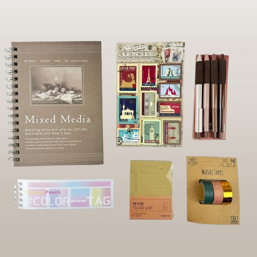 Collection of stationery items including a notebook, stickers, washi tape, and color tags on a light gray background.