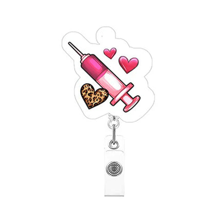 Retractable badge holder with pink syringe design, hearts, and leopard print heart on a white background.
