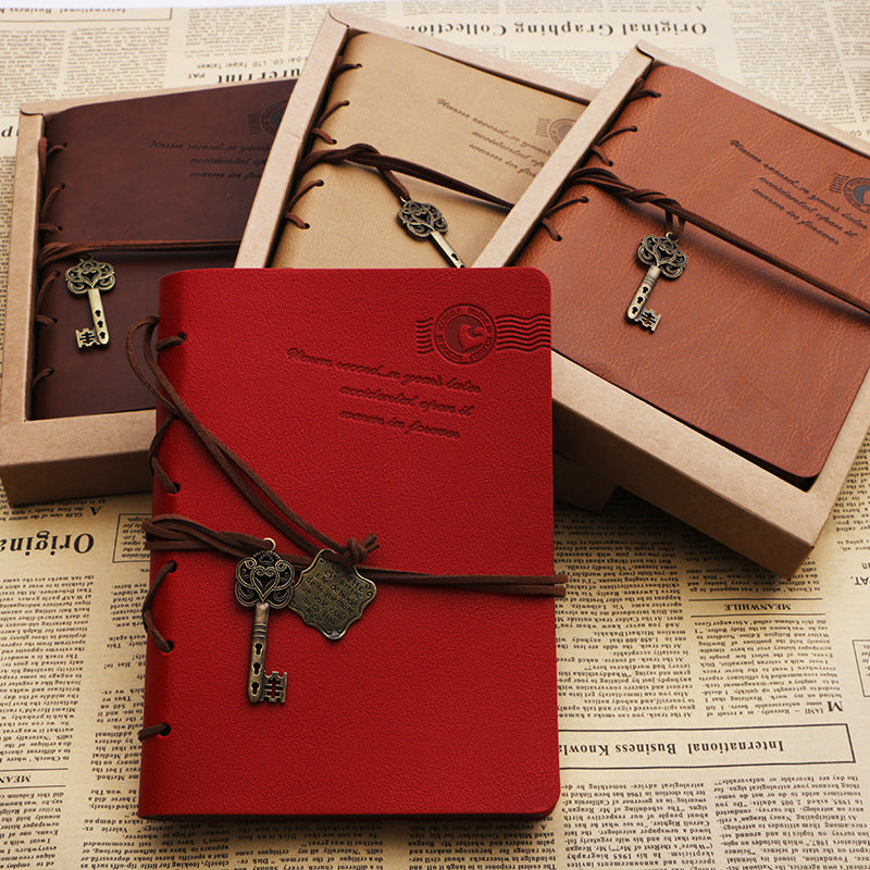 A collection of retro style leather-covered journals with straps and brooches, available in different colors.