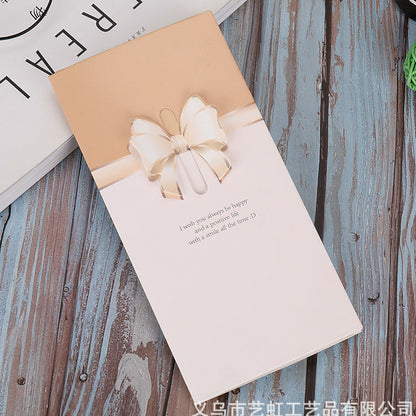 Gift box greeting card with a bow on a wooden surface