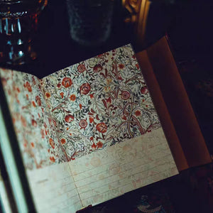 Open notebook with floral patterned pages on a dark background