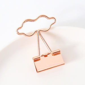 Rose gold cloud-shaped clip on a light background