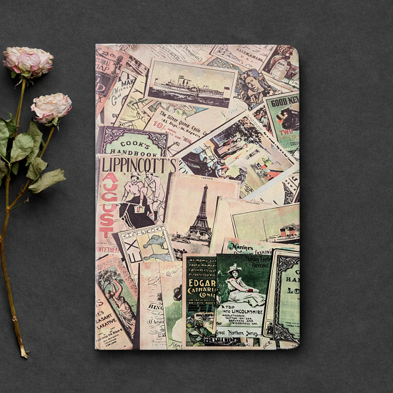 Notebook with vintage-style collage cover on a dark surface with flowers.