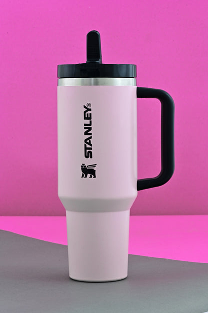 Pink Stanley mug with black handle on a pink background