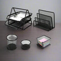 Set of black mesh desk organizers on a gray surface with a neutral background