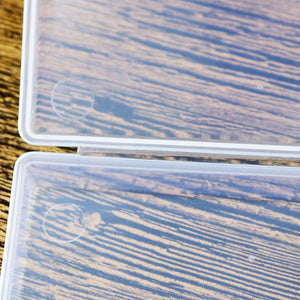 Two clear plastic containers with wood grain pattern on a wooden surface