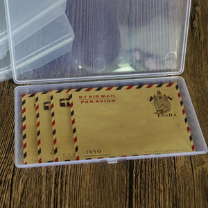 Set of vintage air mail envelopes in a clear plastic case on a wooden surface