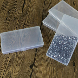 Clear plastic containers with one having glittery contents on a wooden surface