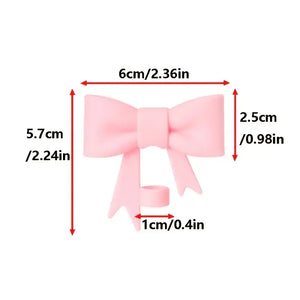 Measurement chart of a pink bow with dimensions labeled in centimeters and inches.