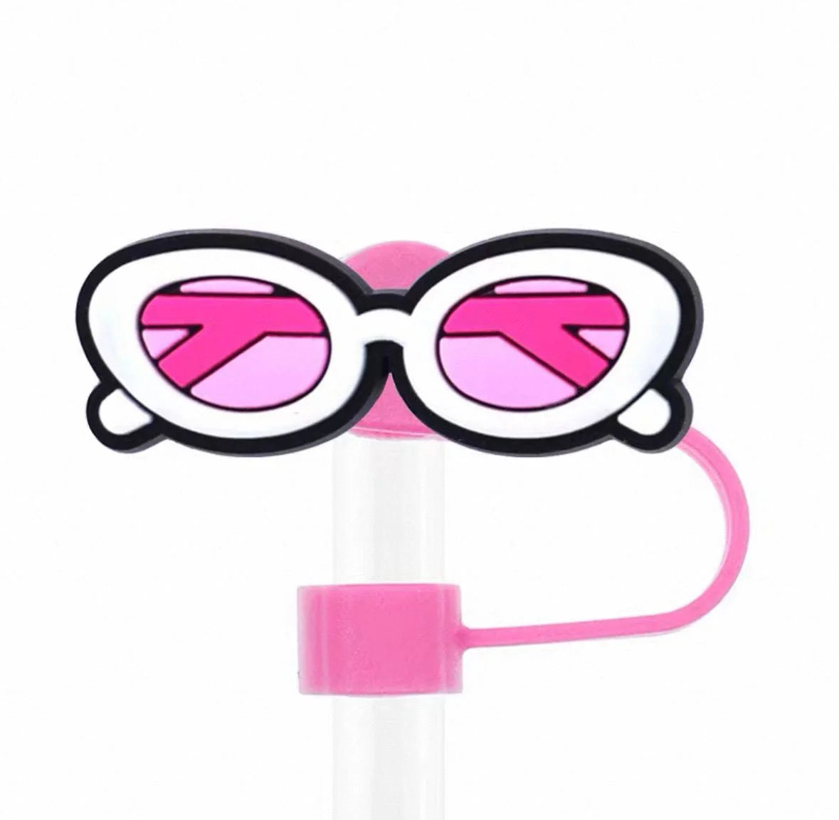Pink and black sunglasses with a straw on a white background