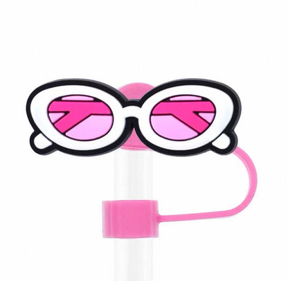 Pink and black sunglasses with a straw on a white background