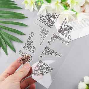 Decorative metal stamps with intricate designs held by a hand, surrounded by flowers and leaves on a light background.